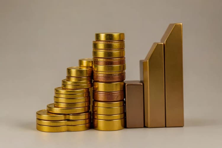 Gráfico abstrato simulando valorização imobiliária com moedas de ouro ao lado