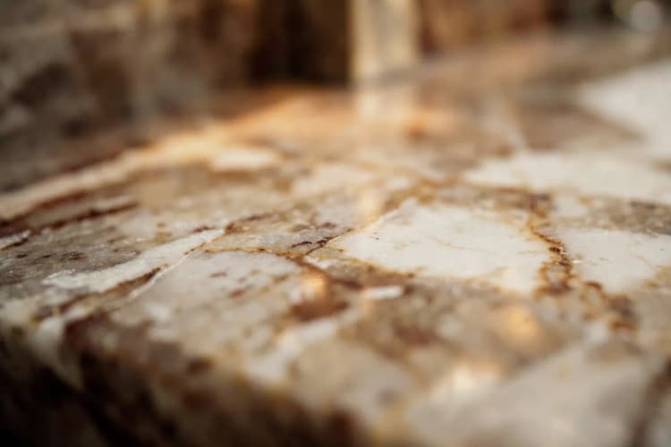 Close-up de um detalhe de acabamento em mármore com veios únicos em um banheiro de luxo