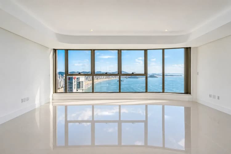 Living integrado do duplex de 421 m² no Yachthouse by Pininfarina, com vista para o mar da Barra Sul